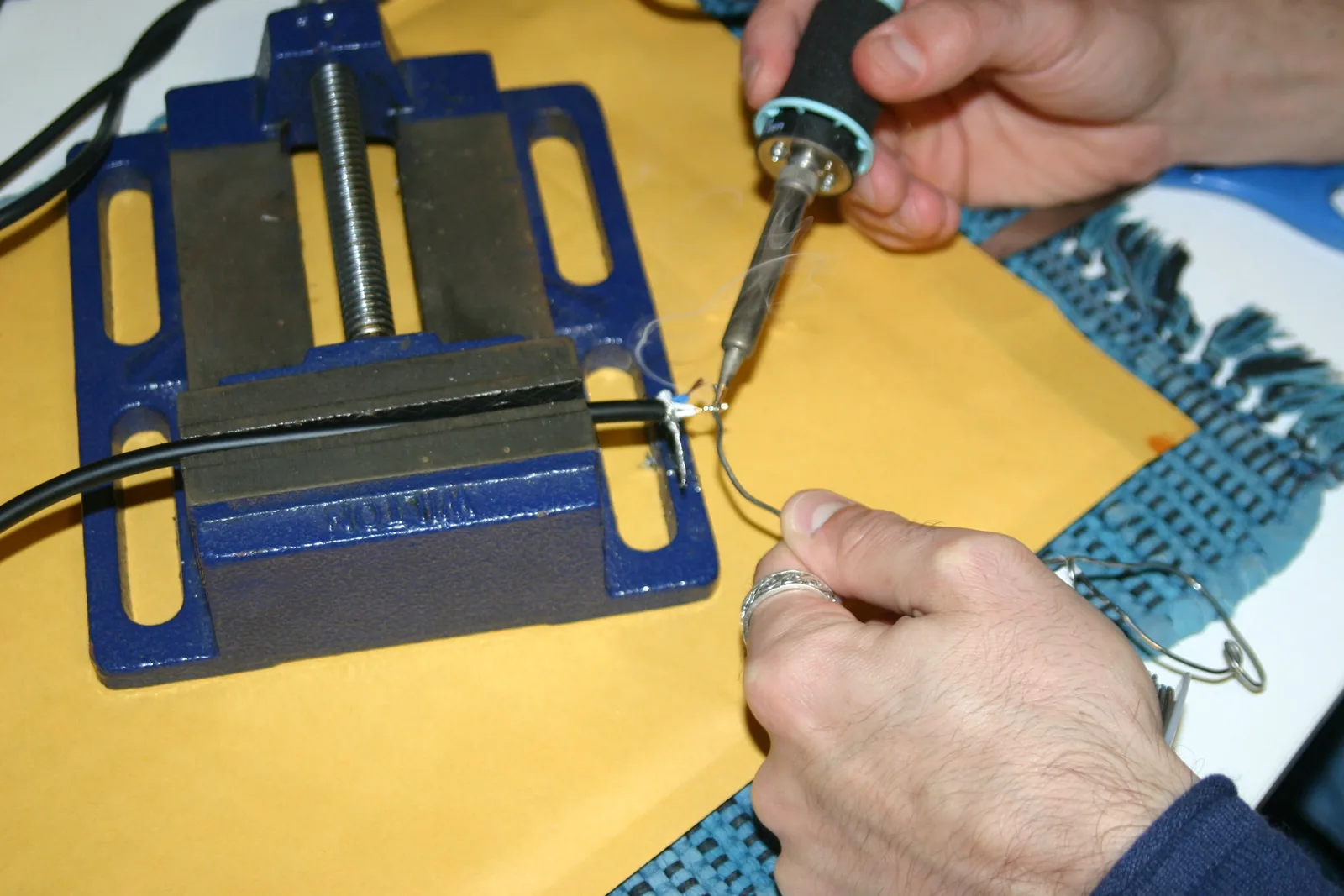 Photo from the book: tinning a stripped conductor with a soldering iron